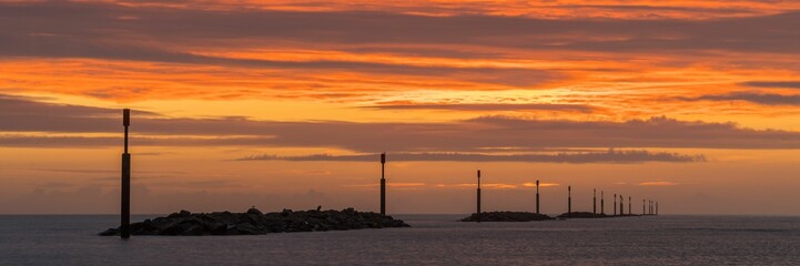 Obraz premium Breathtaking panoramic view of a bright orange sunrise over the horizon of Sea Palling