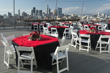 Picturesque outdoor dining area with a table set up on a balcony overlooking a skyline of buildings