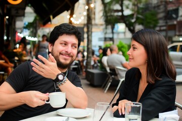 Hot couple in the outdoor cafe enjoying their morning coffee