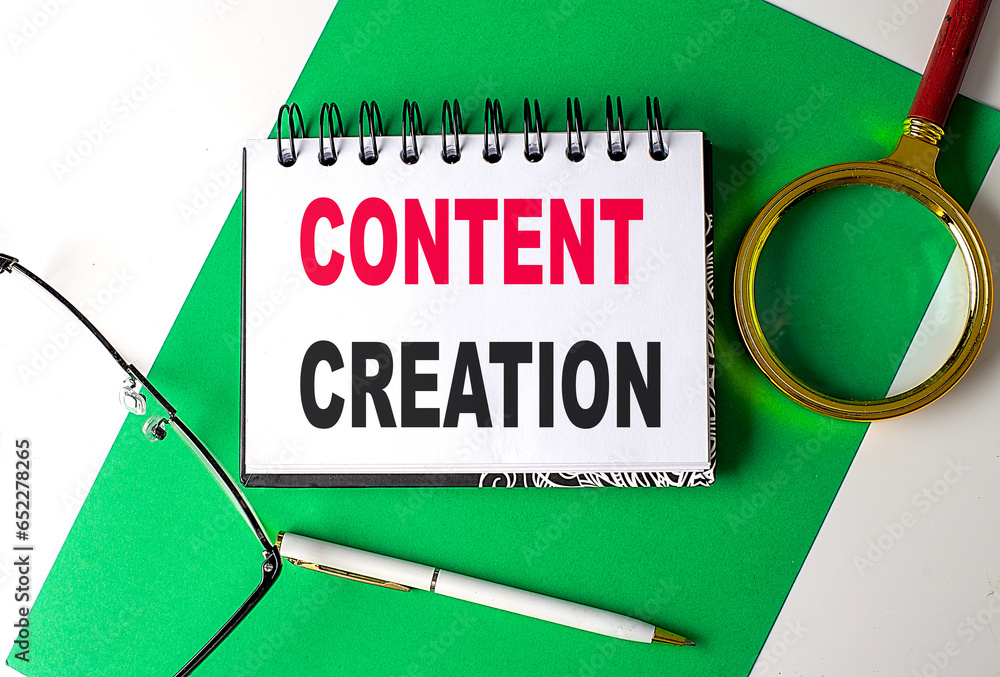 Aufkleber content creation text on notebook on green paper