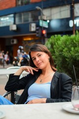 Confident, attractive woman sitting in an outdoor cafe