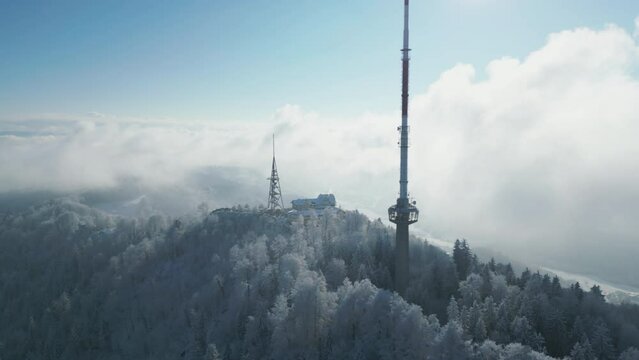 Drone scene of Uetliberg TV-Tower on high forest trees under cloudy sky in Zurich, Switzerland