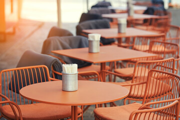 Restaurant terrace on the city street. Empty cafe terrace with tables and chairs. Empty chairs and tables, outdoor restaurant waiting for visitors. Summer patio.