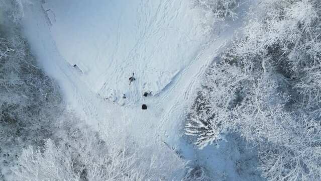 Descending drone over hikers walking on snowy ground glacier in the park