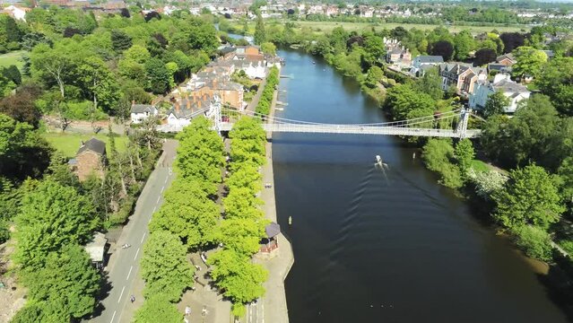 Drone view over a water canal flowing between trees and residence in Chester, UK