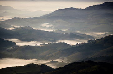 Fototapeta premium Aerial landscape of mountains peaks with pond spaces under mist sky