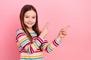 Photo of confident small promoter kid girl indicate fingers empty space recommend her entertainment...