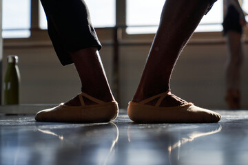 Feet of a professional ballet dancer in a warm-up before rehearsal