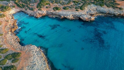 Top-down view of the tranquil turquoise waters of Cala Petita, located in Mallorca