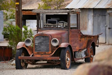 Vintage rusty truck in a field with other aged vehicles, giving off a nostalgic, rural feel