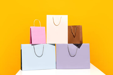 Sale offer. Black Friday. Shopping delivery. Five purchase colorful paper bags isolated on yellow...