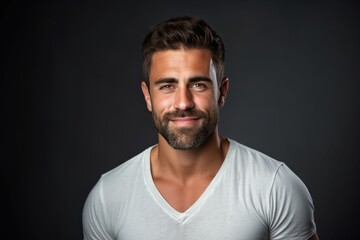 Naklejka premium Portrait of a handsome young man smiling at the camera while standing against beige background