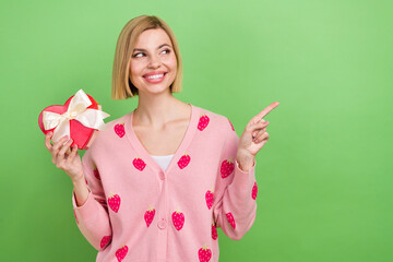 Photo of interested young woman blonde bob hair pink jumper indicate finger novelty candies heart box isolated on green color background - Powered by Adobe
