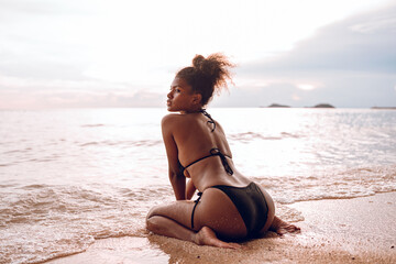 Beautiful African american woman in pink bikini on tropical beach. Portrait of dark skinned woman...