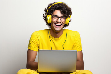 Young man laughing using laptop and headphones