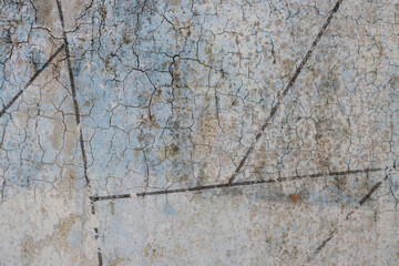 Peeling paint on the wall. Old concrete wall with cracked flaking paint. Weathered rough painted surface with patterns of cracks and peeling. High resolution texture for background and design. Closeup