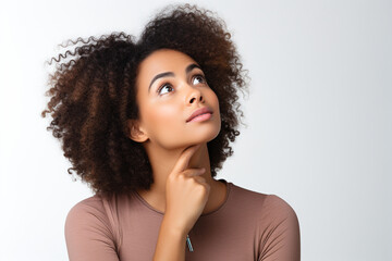 young woman looks up thoughtfully on a white background