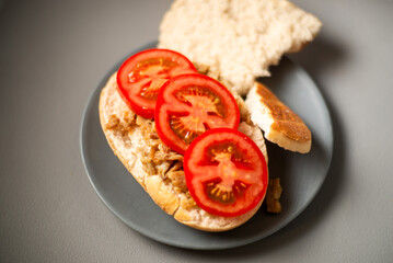 A mouthwatering sandwich in pita bread, featuring flavorful shredded chicken and fresh tomato, beautifully presented on a gray platter