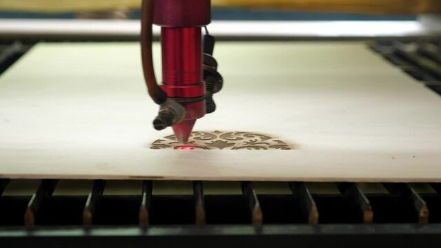 Traditional motifs engraved on wood with CNC laser machine. Image of computer-controlled cnc laser machine for engraving motifs on wood. 