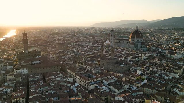 Establishing aerial view shot of Florence city skyline, sunset golden hour, historic city center, Cathedral of Saint Mary of the Flower, Tuscany, Italy