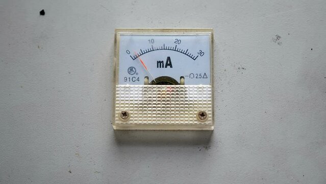 Close-up of a voltmeter at the factory on a white wall. Industrial voltmeter. The arrow moves on the voltmeter at the factory.