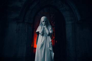 A mysterious figure standing at the entrance of an old medieval crypt shrouded in an eerie white dress, illuminated by a red glow. Mysticism and horror, Halloween. This supernatural and the unknown.