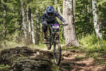 Fototapeta na wymiar racing mtb mountain bike, athlete rider downhill forest trail, extreme sport games