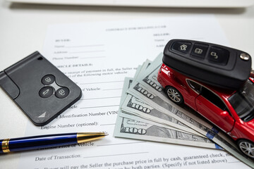 toy car with key, dollar and laptop, document for buy or rent auto at office desk