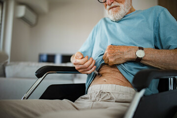 Diabetic senior patient injecting insulin in his belly.