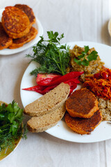 Vegan balanced lunch. Quinoa with stewed vegetables, lentil cutlets, eggplant-squash caviar pate, green buckwheat and millet bread, red pepper, tomato, herbs. Healthy bright useful vitamin-rich dish.