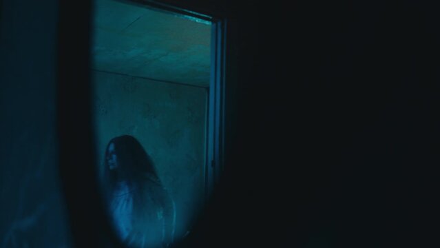 Crazy female serial killer in nightgown walking slowly in room, victim pov