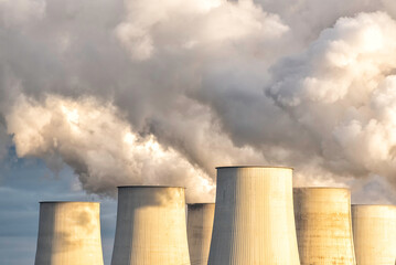 towers of a power plant with hughe exhaust clouds