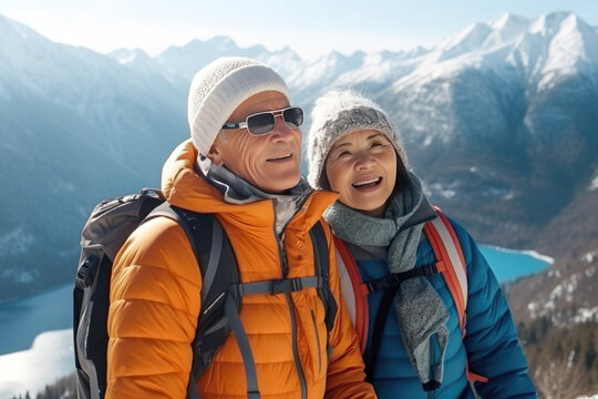 two Asian pensioners hiking in the winter mountains. Healthy lifestyle for older people.