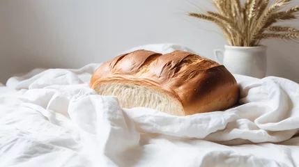 Crédence de cuisine en verre imprimé Pain White fresh puffy loaf of bread on white textile on white background. Light pastel colors, hot freshly baked bread. 