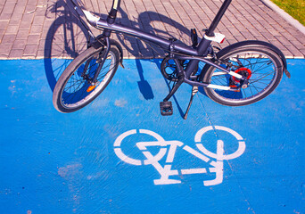 Bicycle icon and half visible bicycle on the blue bicycle path. Photograph