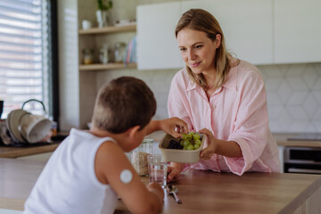 Diabetic boy with a continuous glucose monitor is careful with his diet.