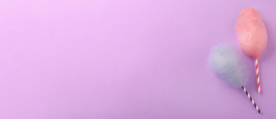 Sweet color cotton candies on violet background, top view. Banner design with space for text