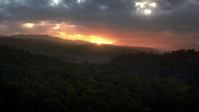 Epic Sunrise over wild forests and mountains with cloudy sky