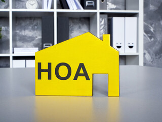 A Yellow model of house with Homeowners Association HOA inscription. - obrazy, fototapety, plakaty