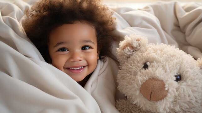 Cute african american baby happiness with teddy bear in a blanket.