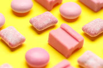 Pink bubble gums on yellow background, closeup