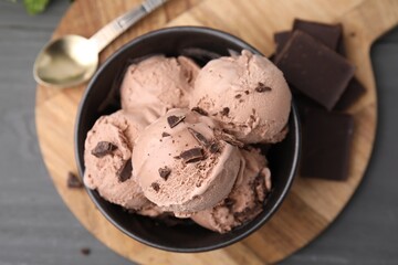 Bowl with tasty chocolate ice cream on wooden board, flat lay