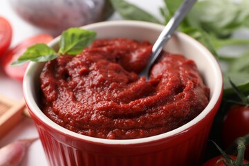Tasty tomato paste in bowl on table, closeup