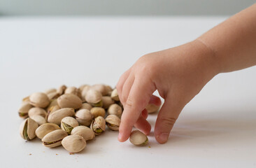 baby holding a handful of nuts
