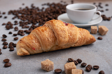 Espresso and croissant with coffee beans