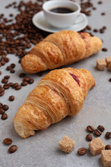 Espresso and croissant with coffee beans