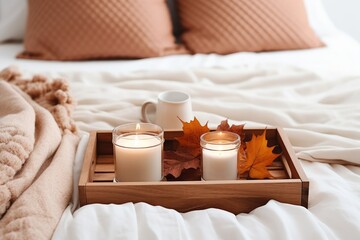 Fototapeta na wymiar Wooden tray with atmospheric candles and aututmn fall leaves on white bed.