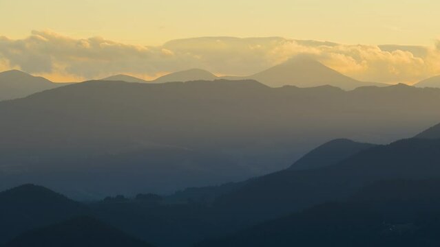 Shepherd houses on mountain side and dark pine forest. Timelapse of colorful sunset in wild mountains. Beautiful nature landscape