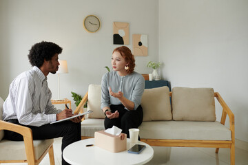 Young woman talking about her relationship problem in office psychologist
