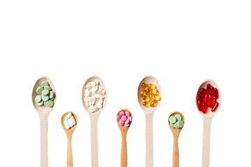 Top view Variety of vitamin and mineral pills in wooden spoon on Colored background. Top view of assorted pharmaceutical medicine pills. Dietary supplement healthcare product